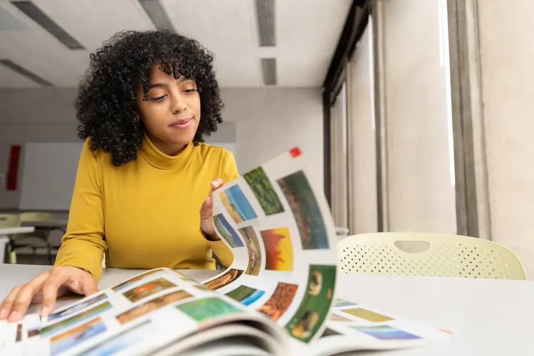 Advertising student, Nico Aramboles '22 flips through a brightly colored book.