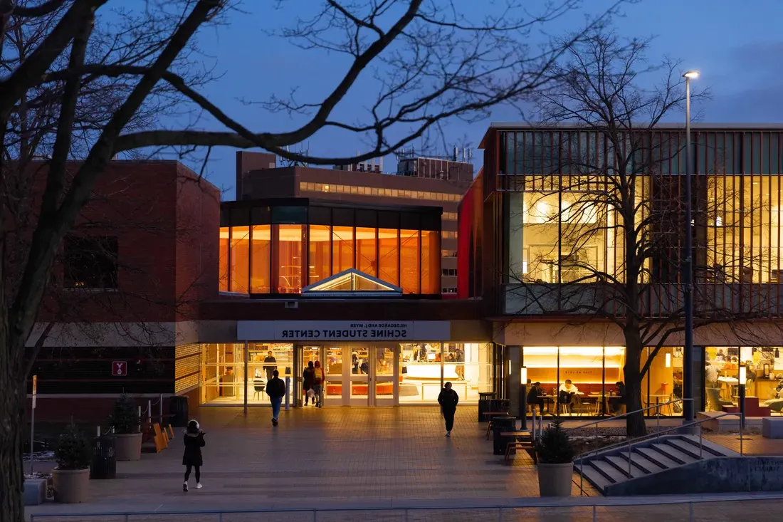 The exterior of the Schine Student Center lit up at dusk.