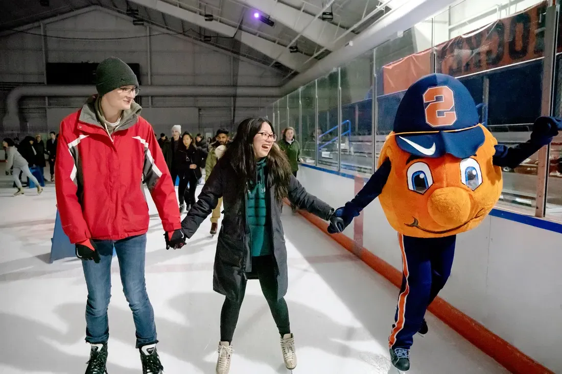 Otto ice skating with two students, all holding hands.