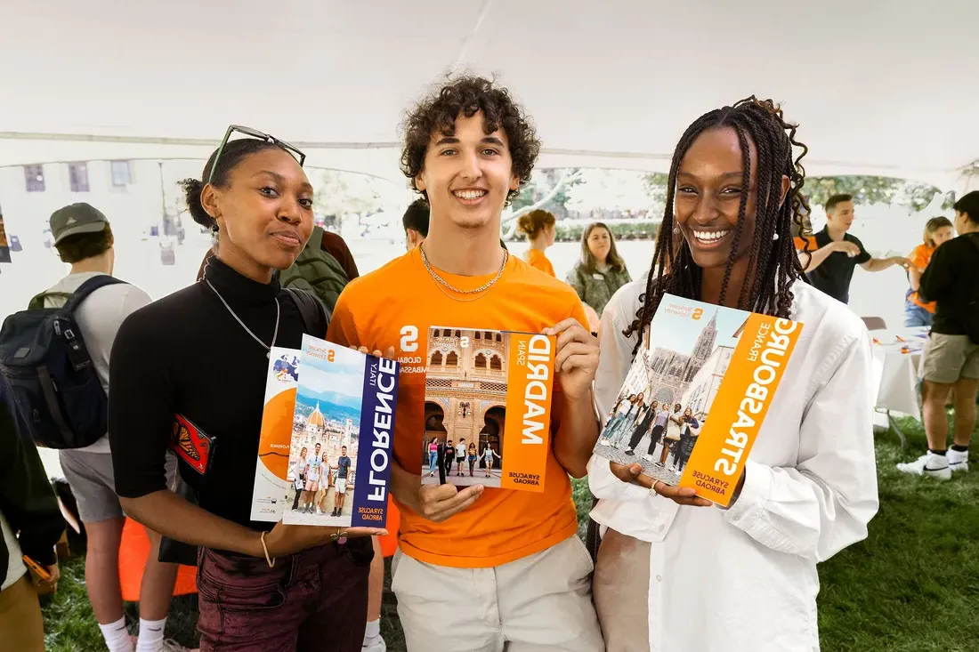 People standing and holding brochures.
